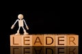 Wood cube block with word Ã¢â¬ÅLEADERÃ¢â¬Â and Wooden Stick Figure standing